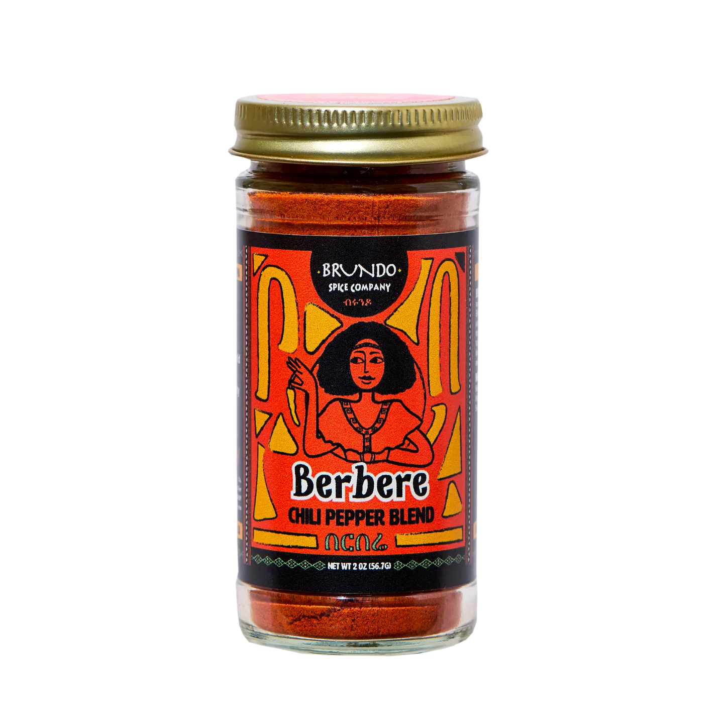 Brundo Spice Company Berbere Chili Pepper Blend jar placed on a bed of black seeds, dried chilies, peppercorns, garlic, and ginger.