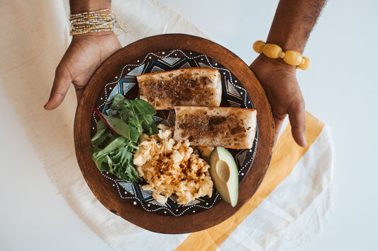 Plate with Niter Kibbeh and Berbere Scrambled Eggs, Telba on toast, and greens