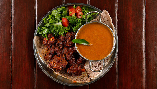 Plate of Begue Wot (Ethiopian Lamb Stew), served with shiro mitten over injera