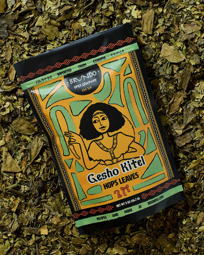 Brundo Spice Company Gesho Kitel Ethiopian hops leaves pouch placed on a bed of dried hops leaves.