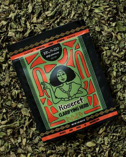 Brundo Spice Company Koseret Clarifying Herb pouch displayed on a bed of dried Ethiopian koseret leaves.