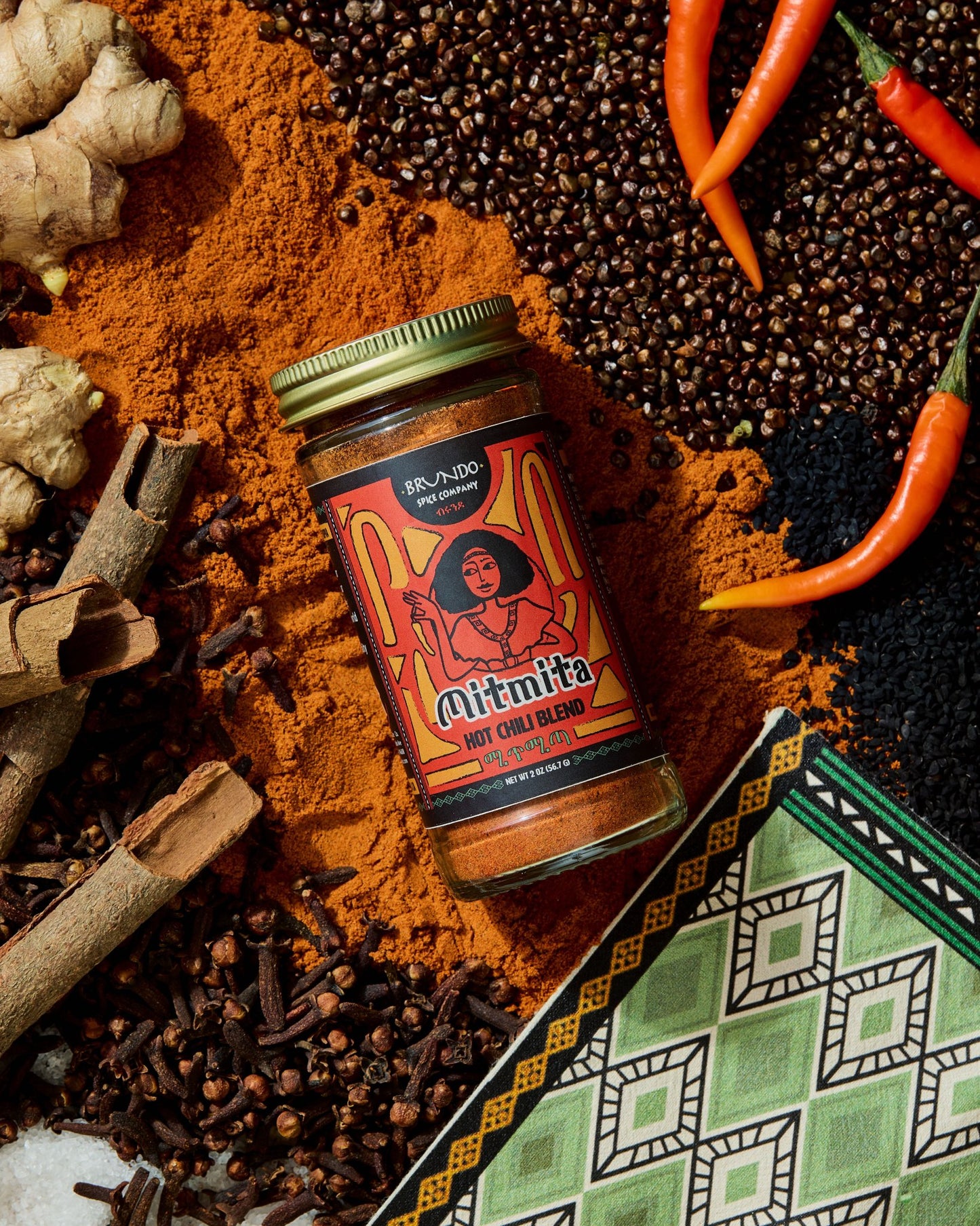 Brundo Spice Company Mimita Hot Chili Blend in a glass spice jar with a gold lid on a white background.
