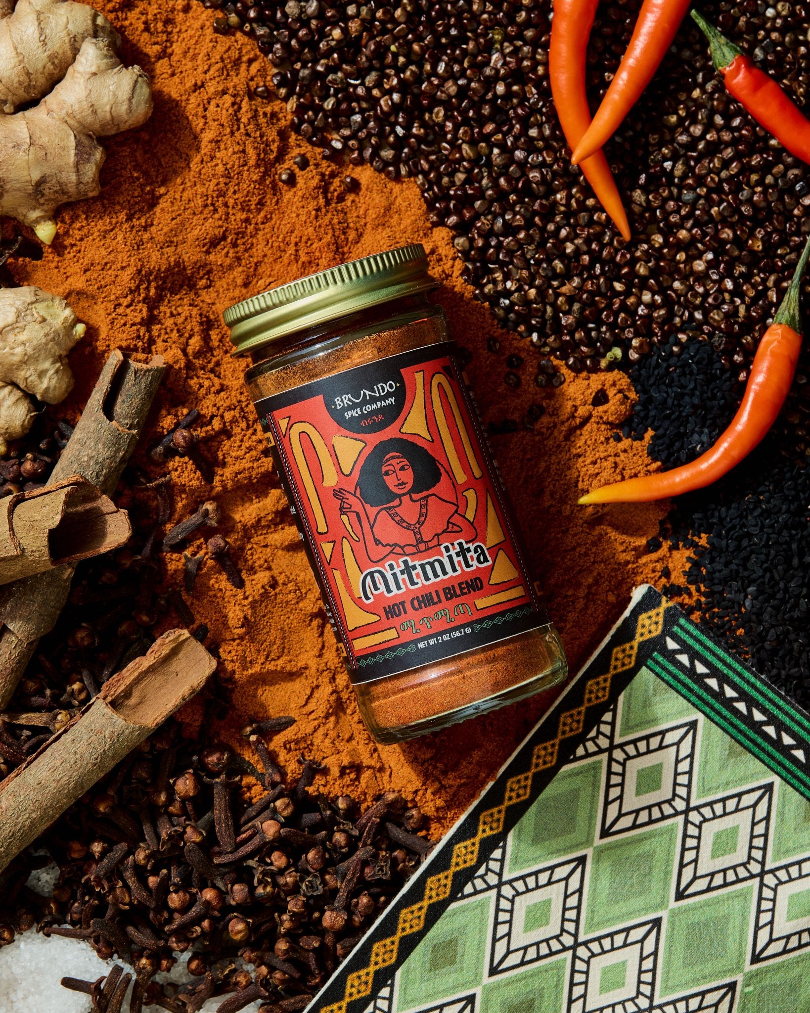 Brundo Spice Company Mimita Hot Chili Blend in a glass spice jar with a gold lid on a white background.